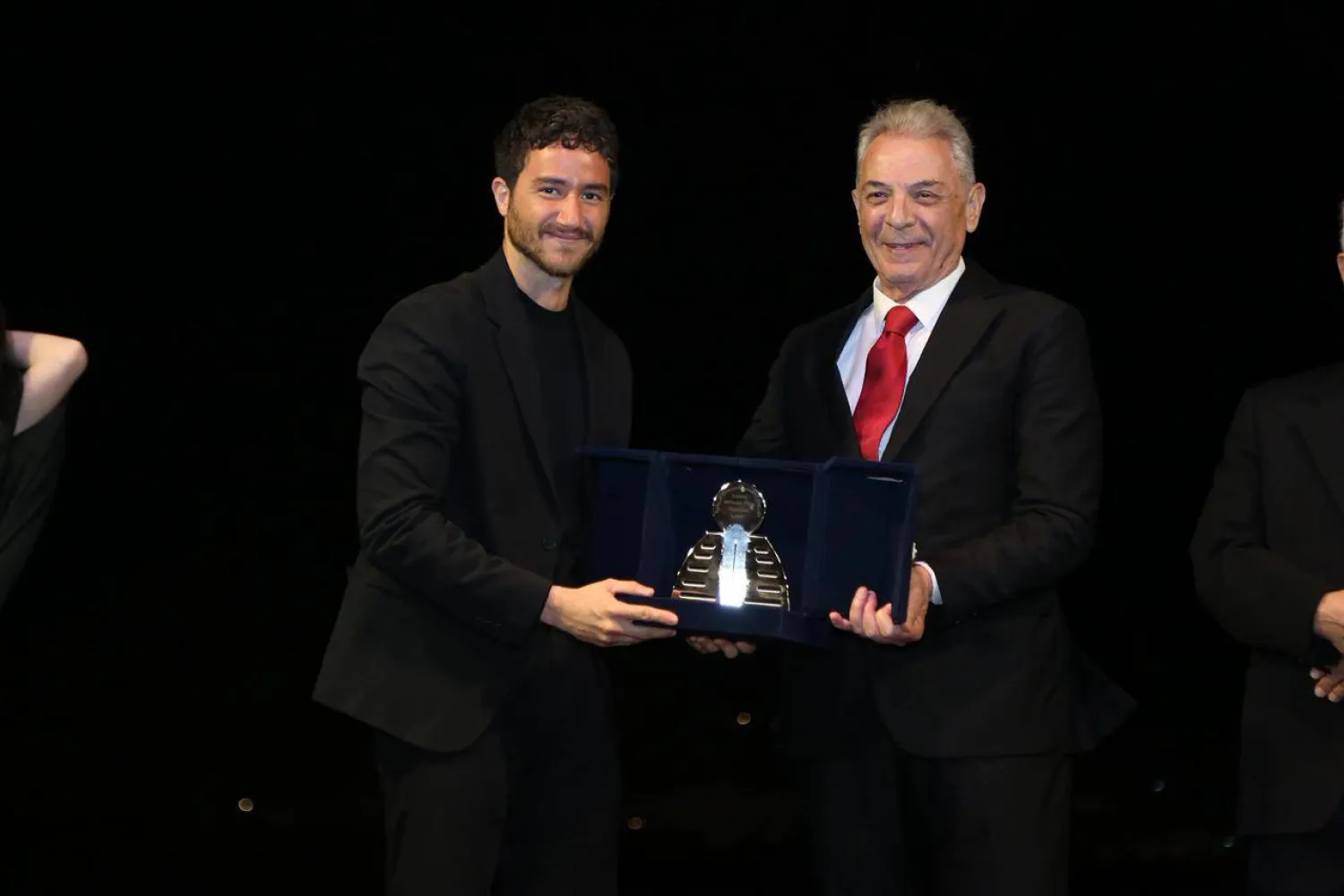 أحمد مالك متسلماً الجائزة من الرئيس الشرفي للمهرجان محمود حميدة (إدارة المهرجان)
