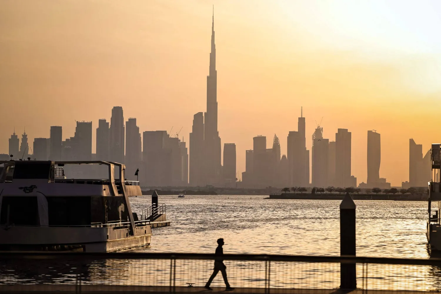  A man walks along Dubai's Creek Harbor, with the Burj Khalifa visible in the background, on April 3, 2026. (AFP) 
