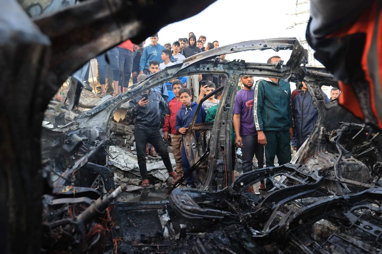 Palestinians inspect a vehicle targeted by an Israeli strike in Maghazi camp for Palestinian refugees in the central Gaza Strip on April 4, 2026. (AFP)