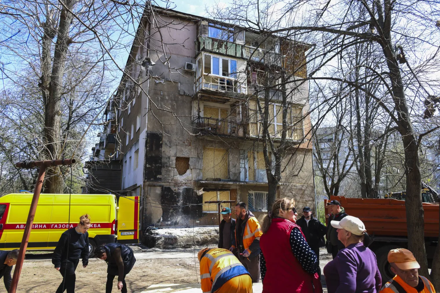 عمال مجالس محلية يعملون بموقع غارة روسية على مبنى سكني في أوديسا بأوكرانيا الأحد (إ.ب.أ) 