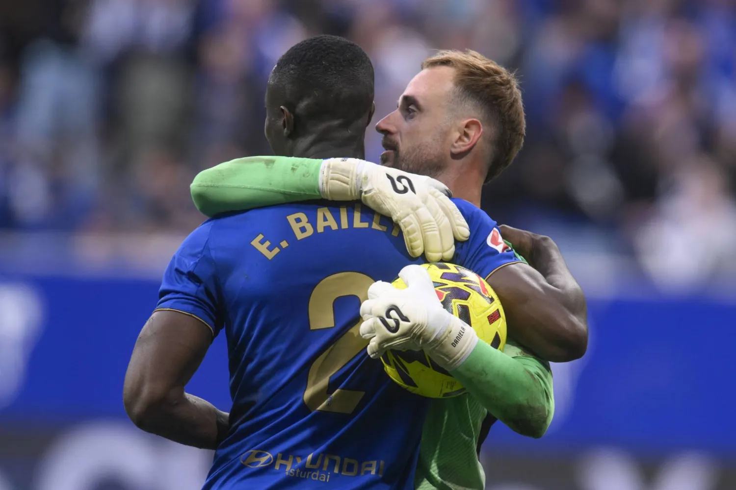 إيريك بايلي لاعب أوفييدو يحتفل مع حارس مرماه آرون سكانديل بالفوز على إشبيلية (إ.ب.أ)