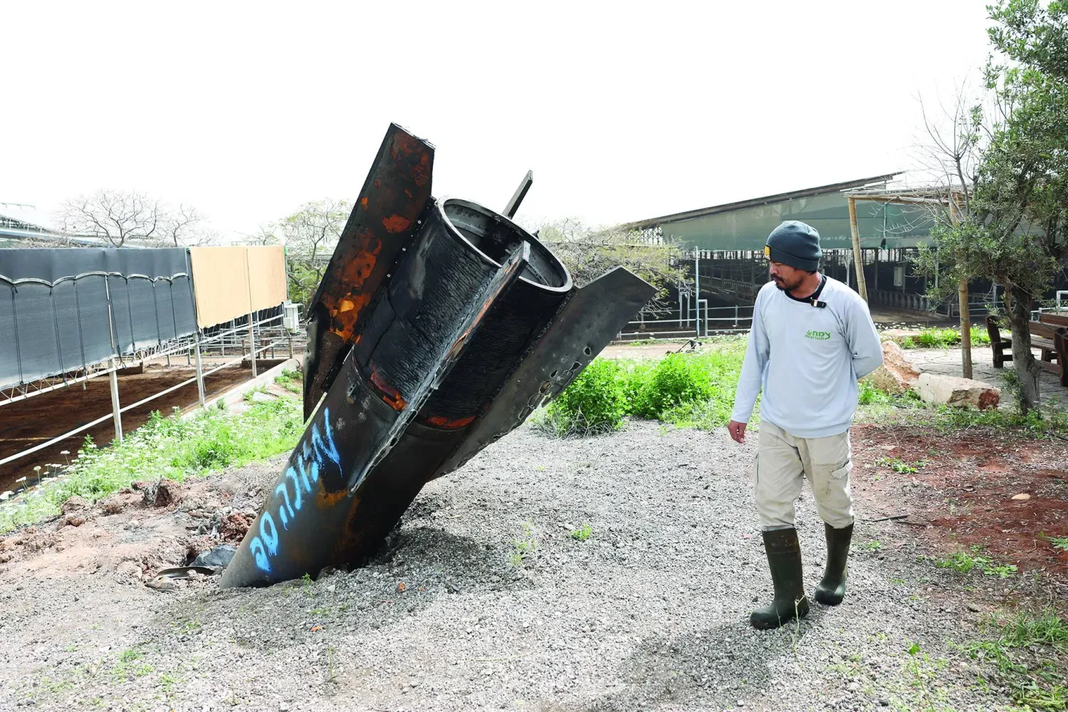 Maşur kentindeki petrokimya kompleksinde yangın çıkarken fotoğrafta Batı Şeria'daki bir İsrail yerleşiminde bir sığır çiftliğine düşen bir İran füzesinin kalıntıları görülüyor (EPA)