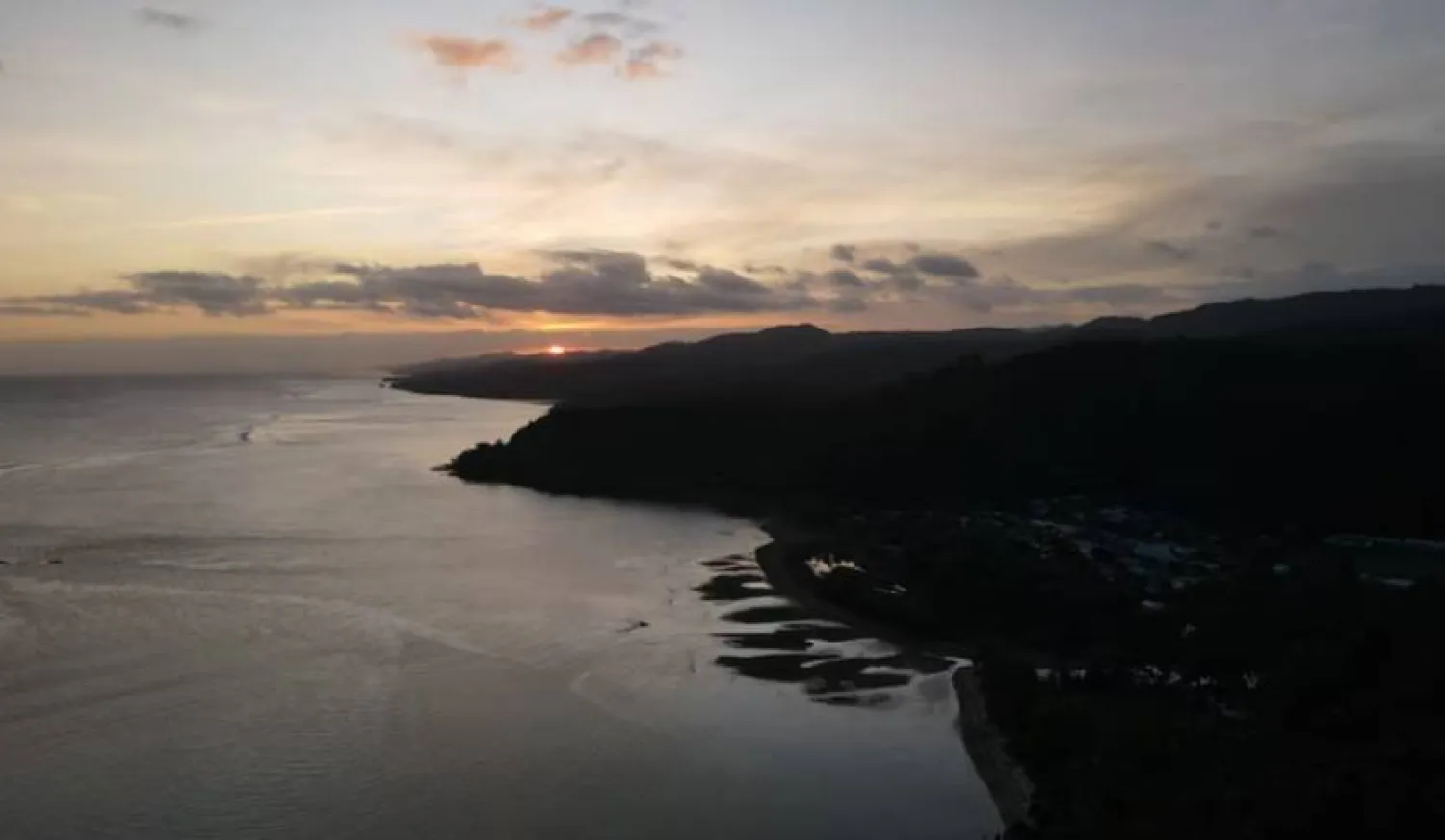 An aerial view shows the sunset behind Namatakula village, Coral Coast, Fiji July 9, 2022. REUTERS/Jill Gralow