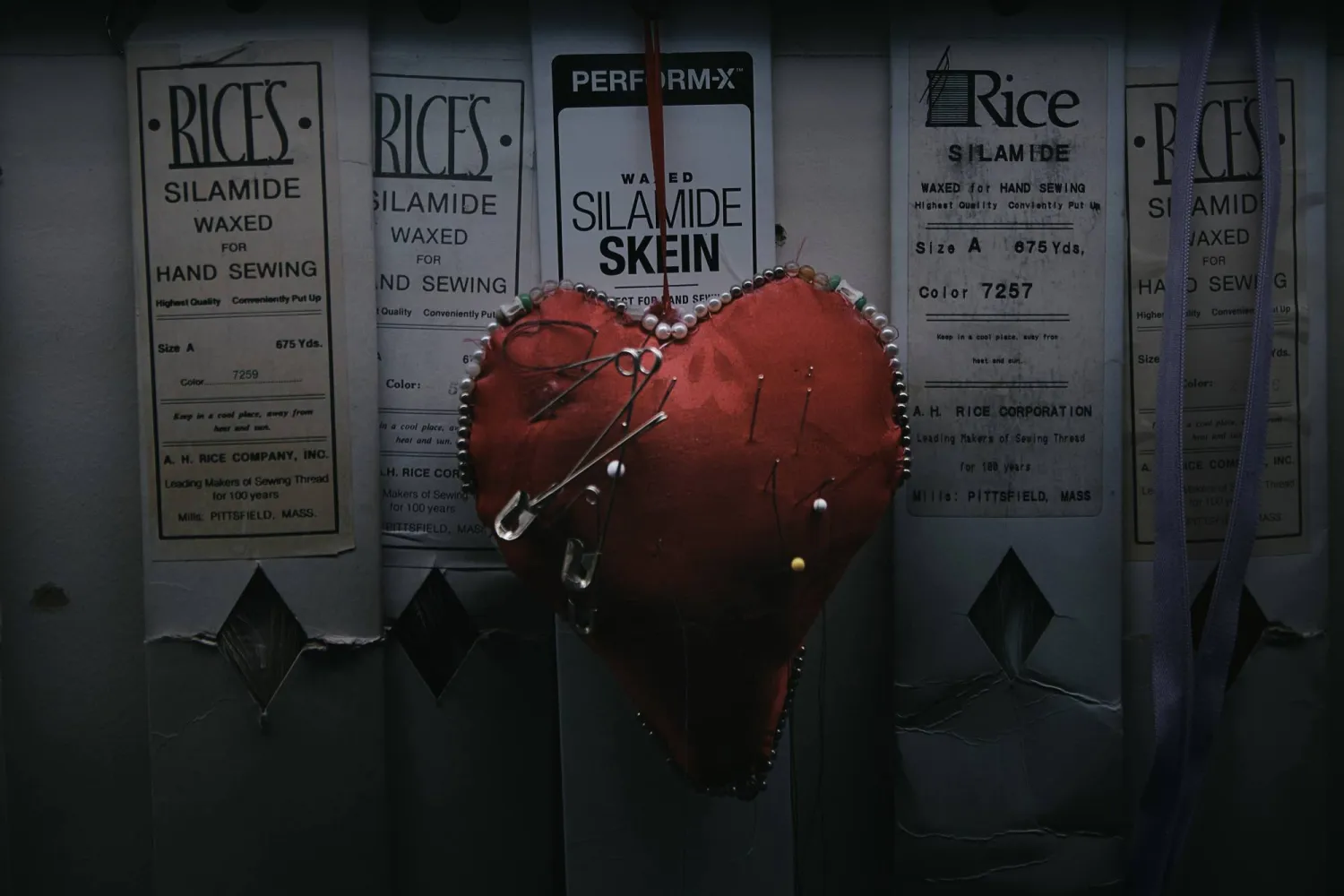 A heart-shaped pincushion bristling with needles hangs on the wall inside Kil Bae's store on Friday, March 27, 2026, in New York. (AP Photo/Andres Kudacki)