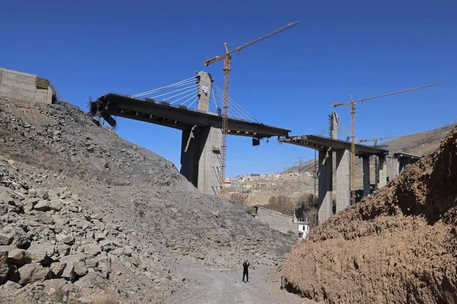 A man takes pictures with his mobile phone of the B1 bridge, a day after it was destroyed by a strike in Karaj, around 20miles (35kms) southwest of Tehran, April 3, 2026. (AFP)