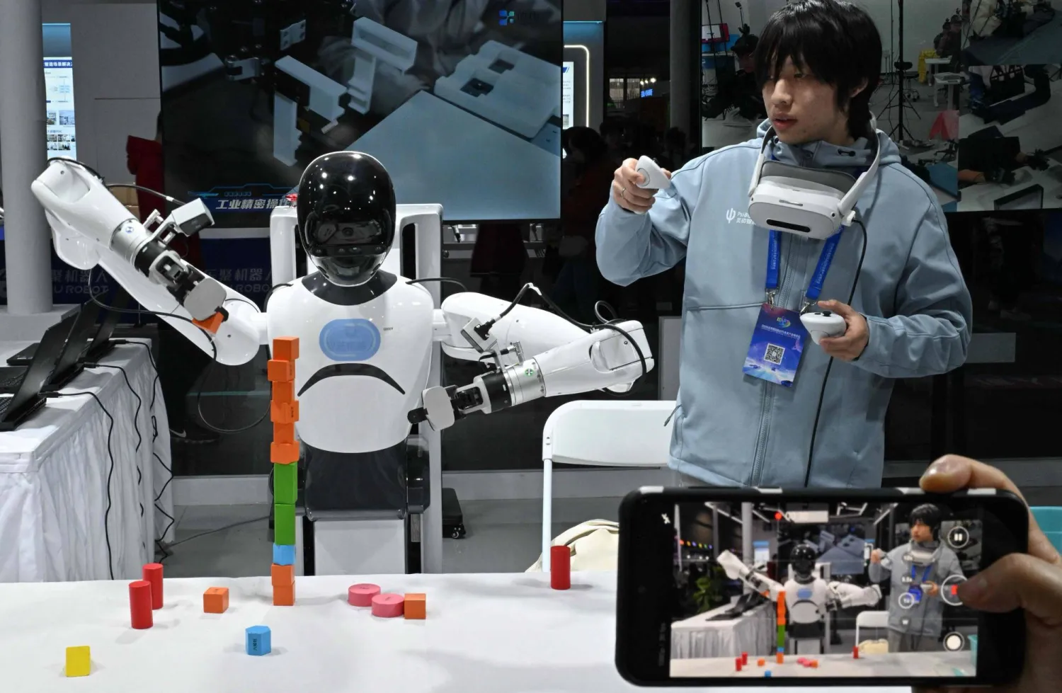 مهندس يتحكم في روبوت من شركة «تاشان» خلال مهرجان بكين (أ.ف.ب)