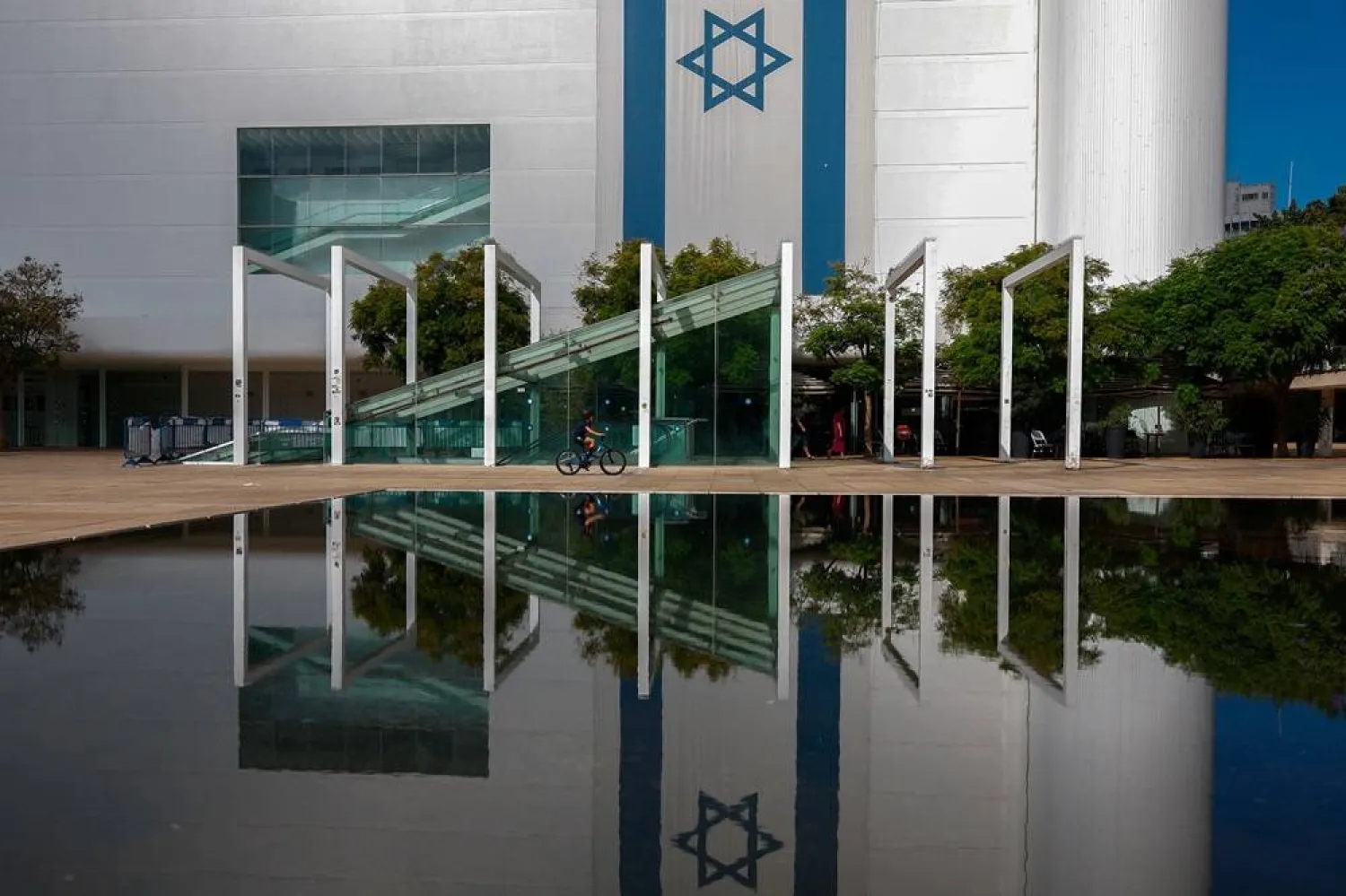 A boy rides his bicycle past an Israel flag on Yom Kippur in Tel Aviv, Israel October 12, 2024. (Reuters)