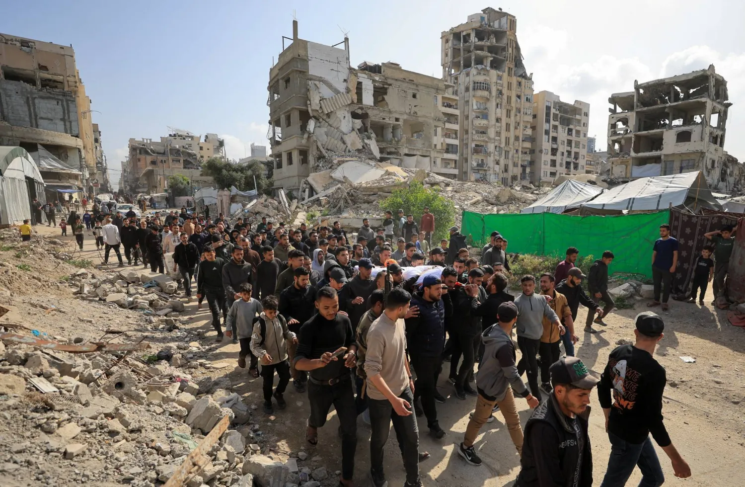 مشيعون يحملون يوم الاثنين جثمان الفلسطيني عبد الرحمن الخضري الذي قُتل في غارة إسرائيلية في مدينة غزة يوم الأحد (رويترز)