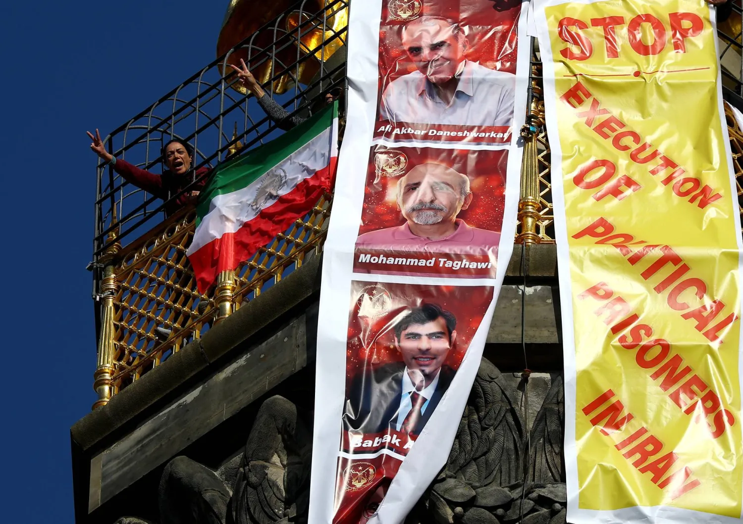 إيرانيون في المنفى يحتجون برفع لافتة كُتب عليها «أوقفوا إعدام السجناء السياسيين في إيران» أعلى عمود النصر في برلين بألمانيا 2 أبريل 2026 (رويترز)