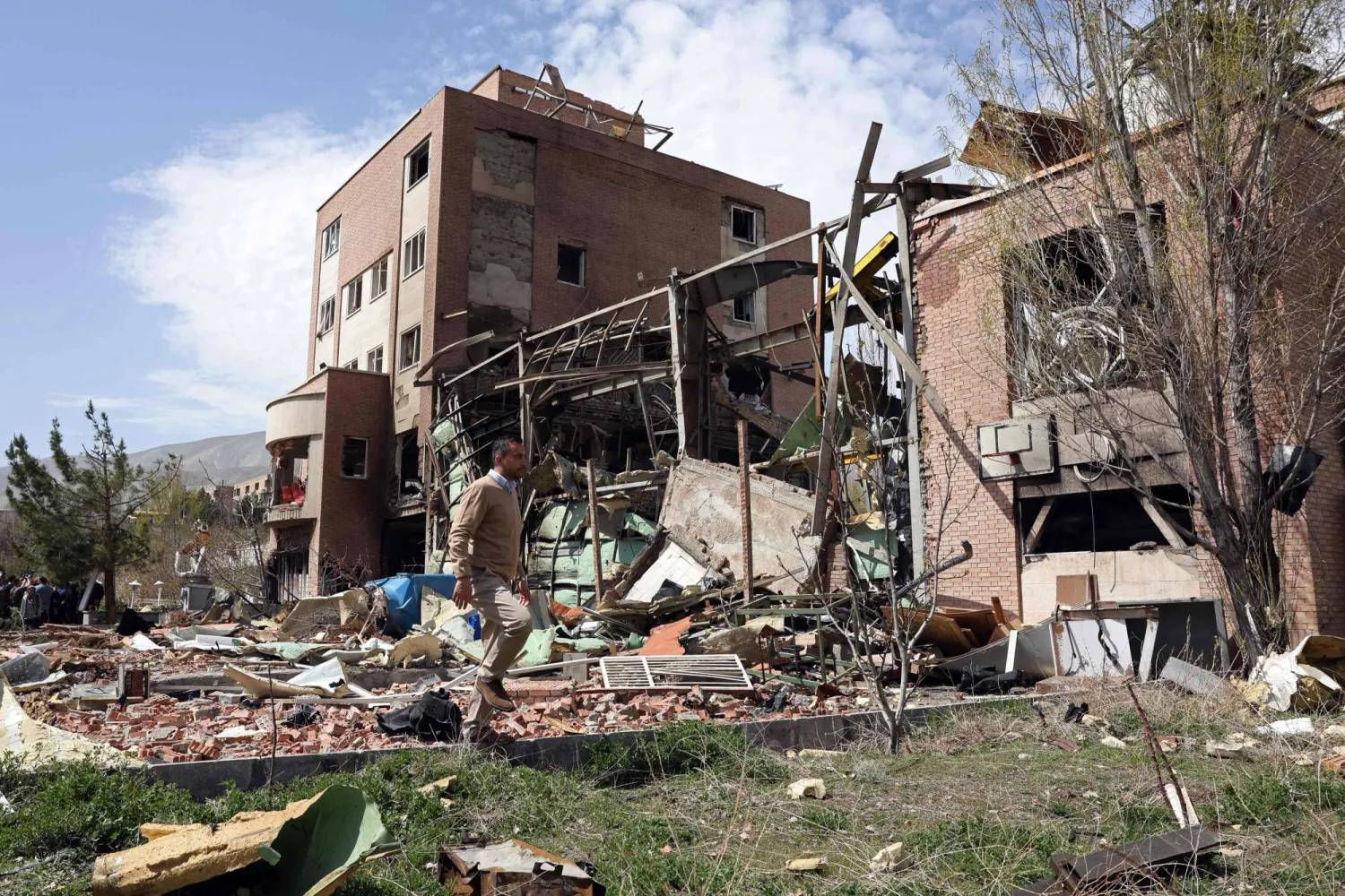 A man walks past the damaged building of the Shahid Beheshti University following a strike, in Tehran on April 4, 2026. (AFP)