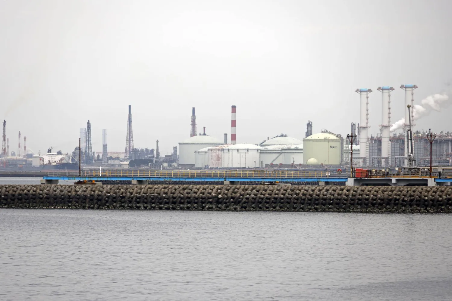 خزانات تخزين النفط الخام الضخمة تظهر في خلفية الصورة في مصفاة سوديغاورا بمدينة سوديغاورا - محافظة تشيبا - خليج طوكيو (إ.ب.أ)