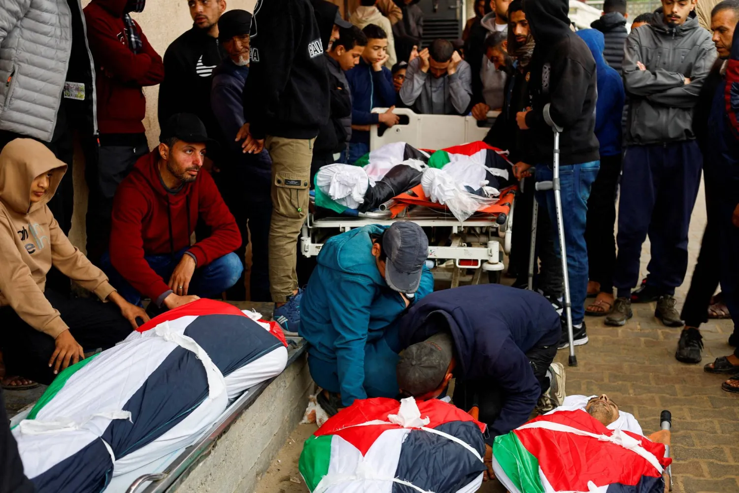 جنازة فلسطينيين قُتلوا بغارة إسرائيلية في مستشفى شهداء الأقصى بدير البلح وسط قطاع غزة (رويترز)