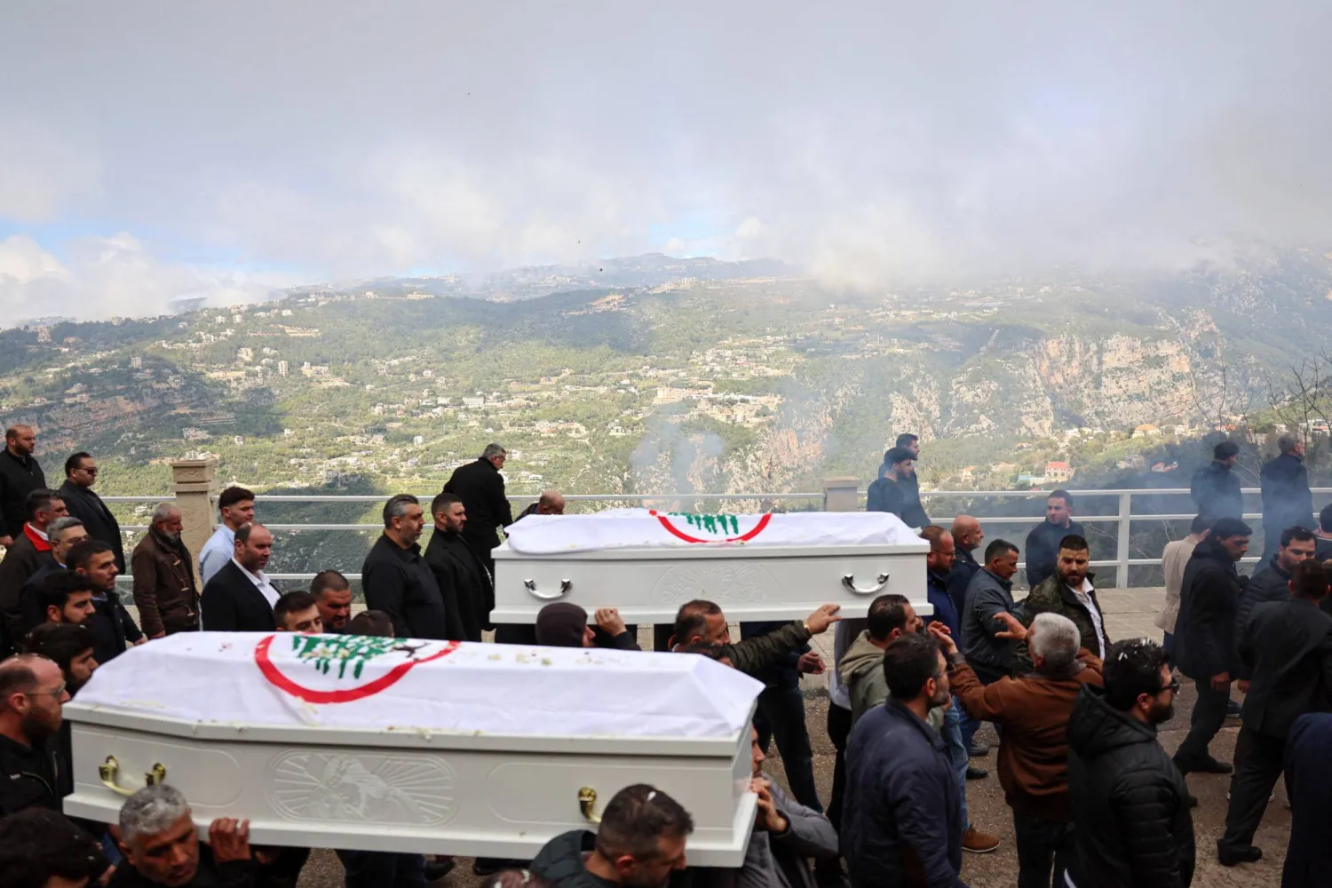 نعشا القيادي في «القوات اللبنانية» بيار معوض وزوجته فلافيا ملفوفتين بعلم «القوات» خلال تشييعهما بعد يومين على مقتلهما بغارة إسرائيلية استهدفت منطقة عين سعادة شرق بيروت (رويترز)