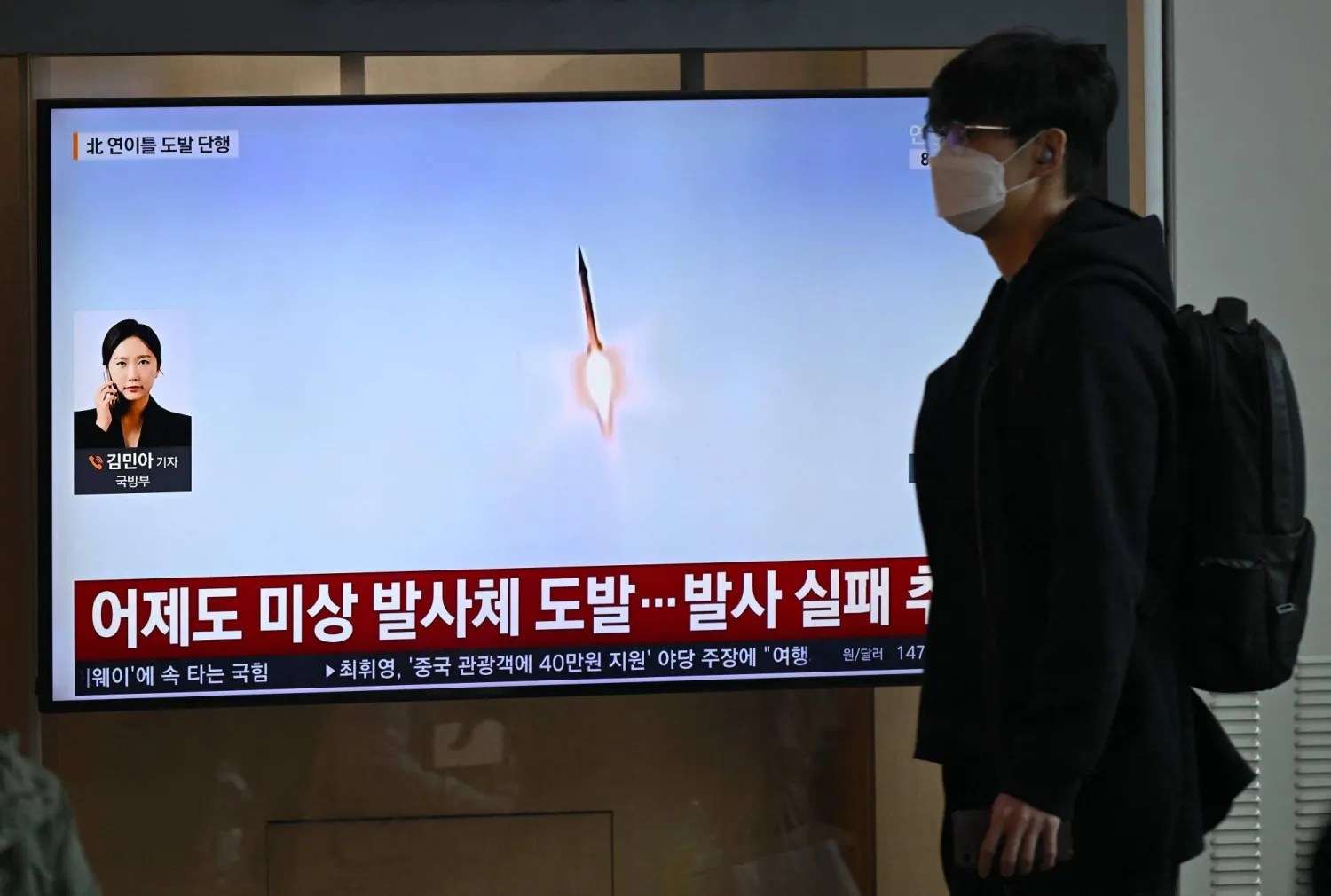 A man walks past a television screen showing a news broadcast with file footage of a North Korean missile test, at a train station in Seoul on April 8, 2026. (Photo by Jung Yeon-je / AFP)