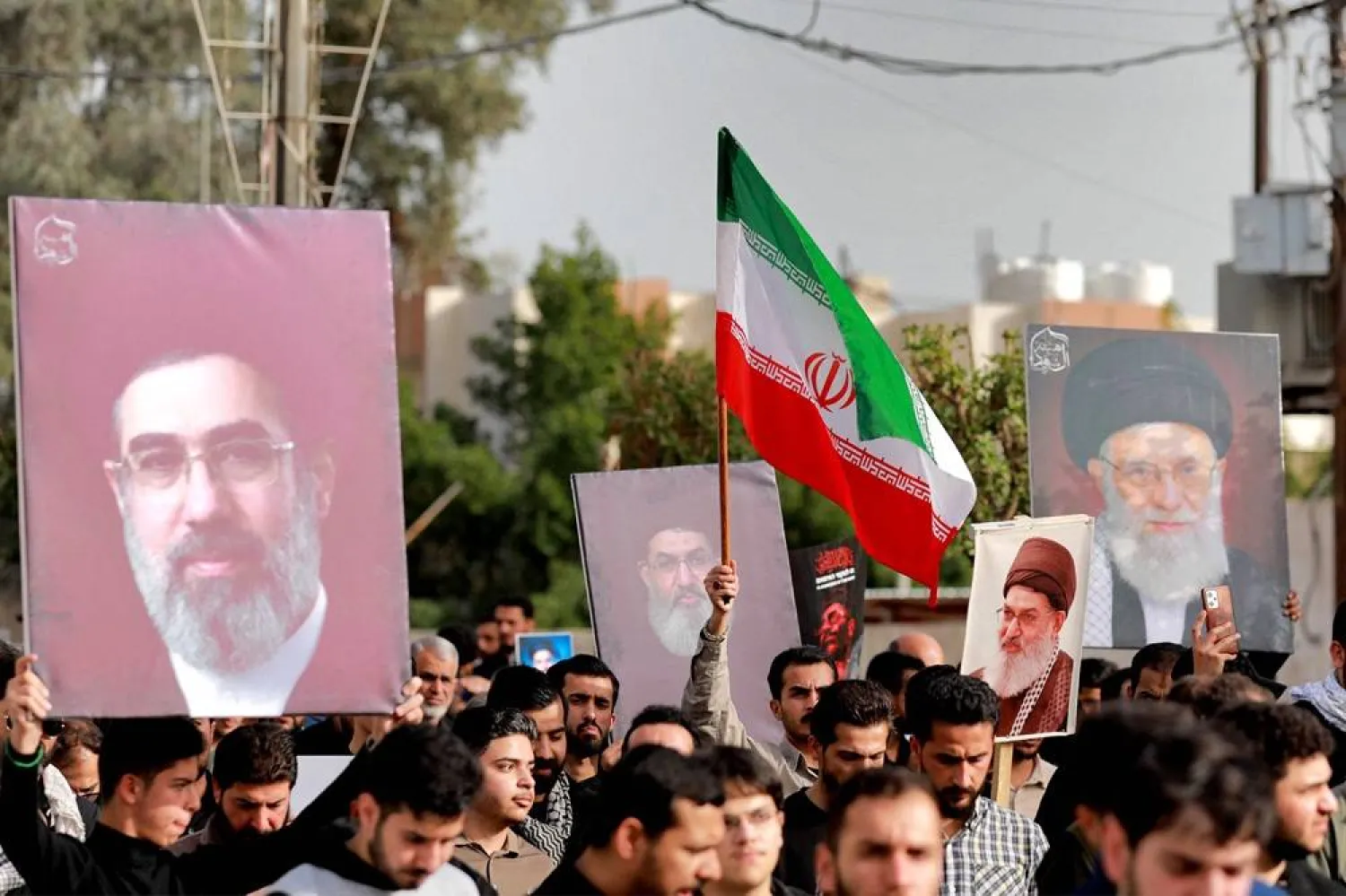 People display pictures of Iran's slain supreme leader Ali Khamenei and his son and successor Mojtaba Khamenei during a demonstration in solidarity with Iran in its war against the US and Israel, in the Kadhimiya district of northern Baghdad on April 3, 2026. (AFP)