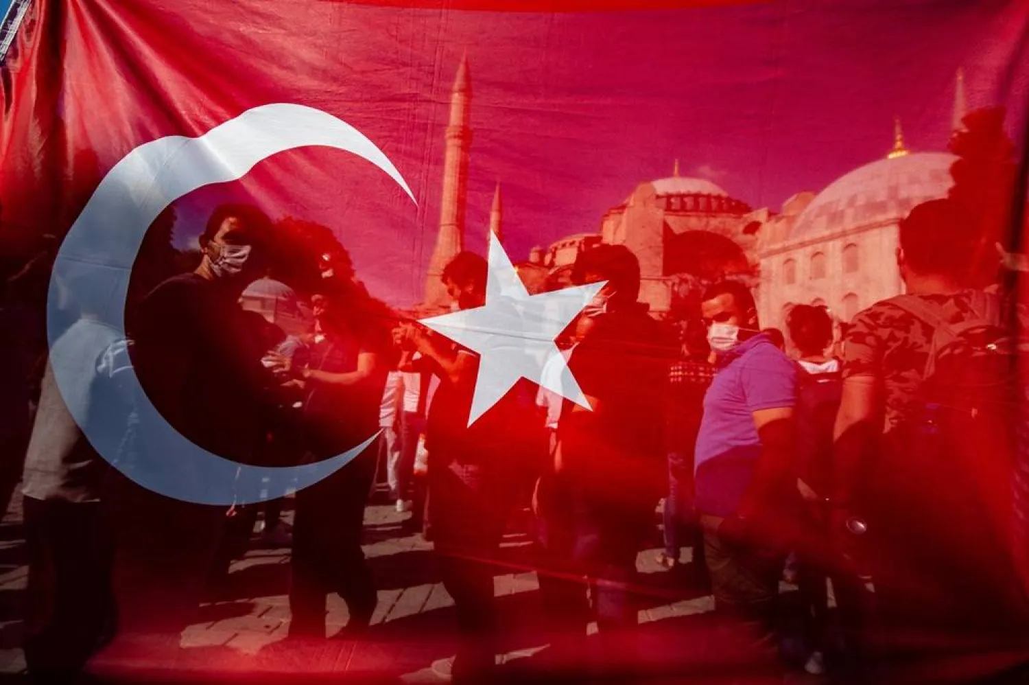 10 July 2020, Türkiye, Istanbul: People stand behind a Turkish national flag in front of Hagia Sophia in Istanbul. (dpa)
