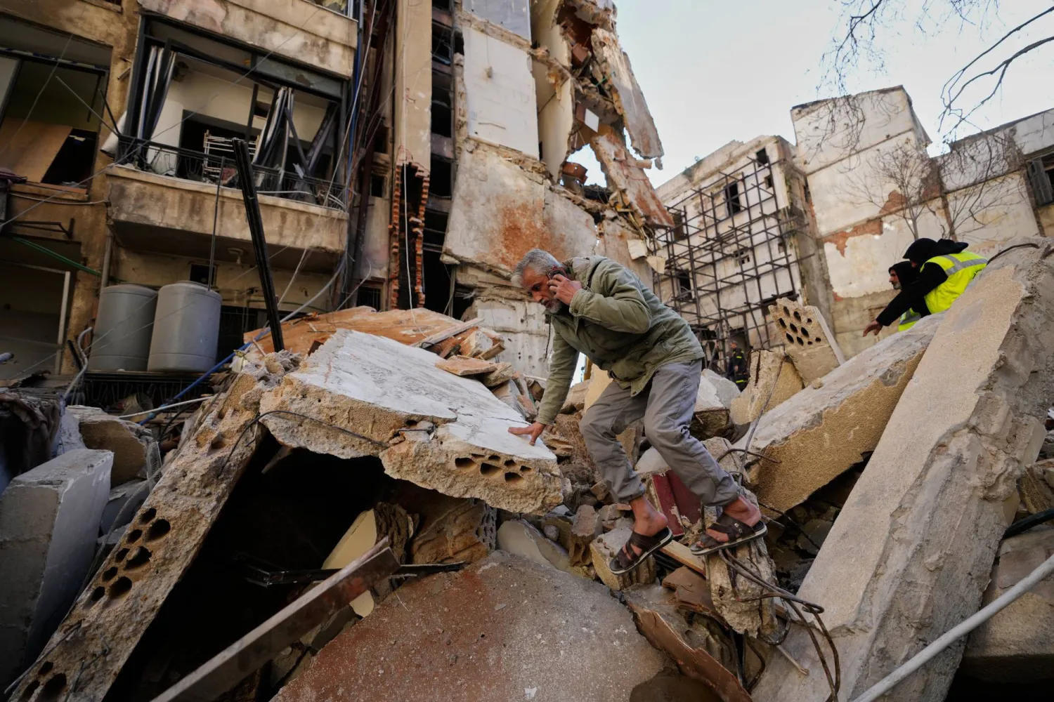 رجل يسير على أنقاض مبنى دمرته غارة جوية إسرائيلية في اليوم السابق بوسط بيروت - لبنان (أ.ب)