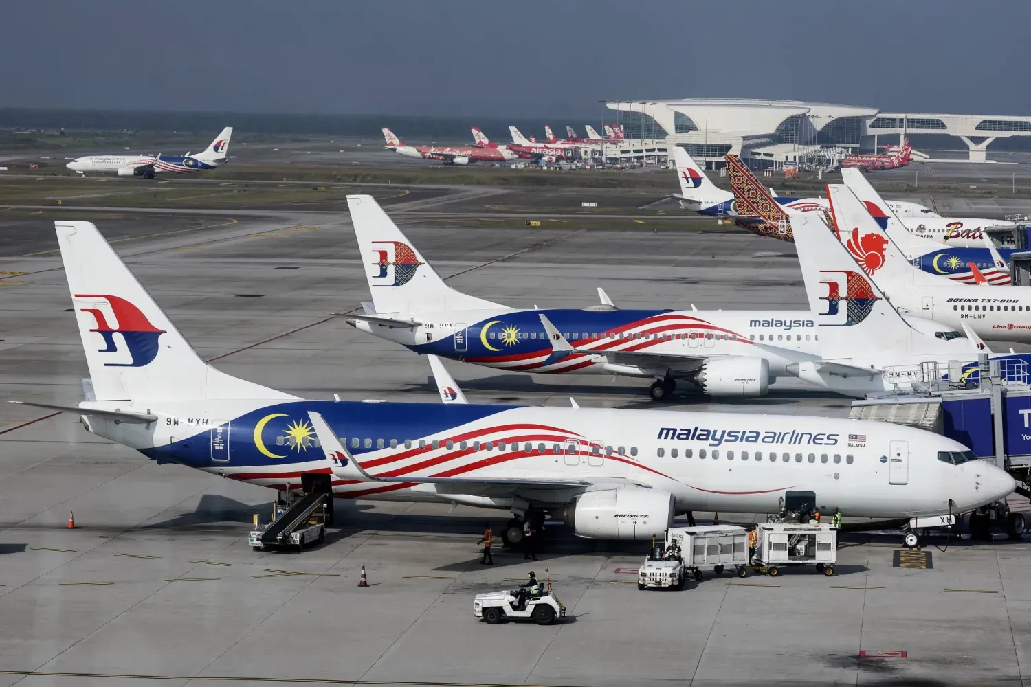 Sepang’daki Kuala Lumpur Uluslararası Havalimanı’nda Malezya Havayolları uçağına bagajları yükleyen işçiler (EPA)