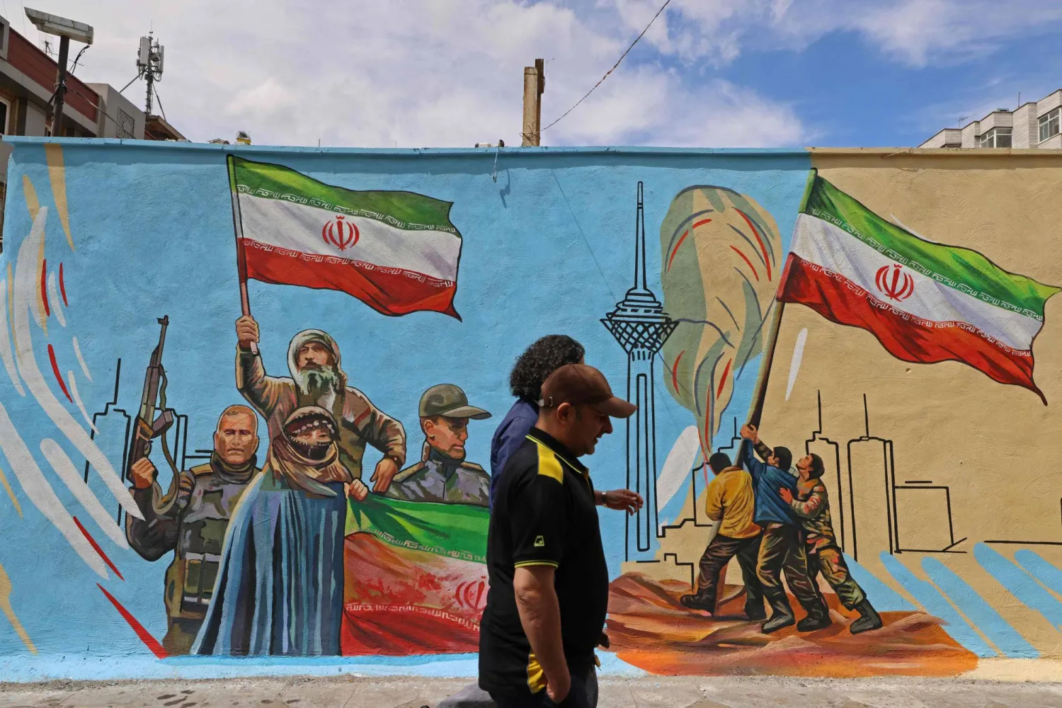 Men walks past an anti-USA and anti-Israel mural, in Tehran on April 8, 2026. (Photo by ATTA KENARE / AFP) / 