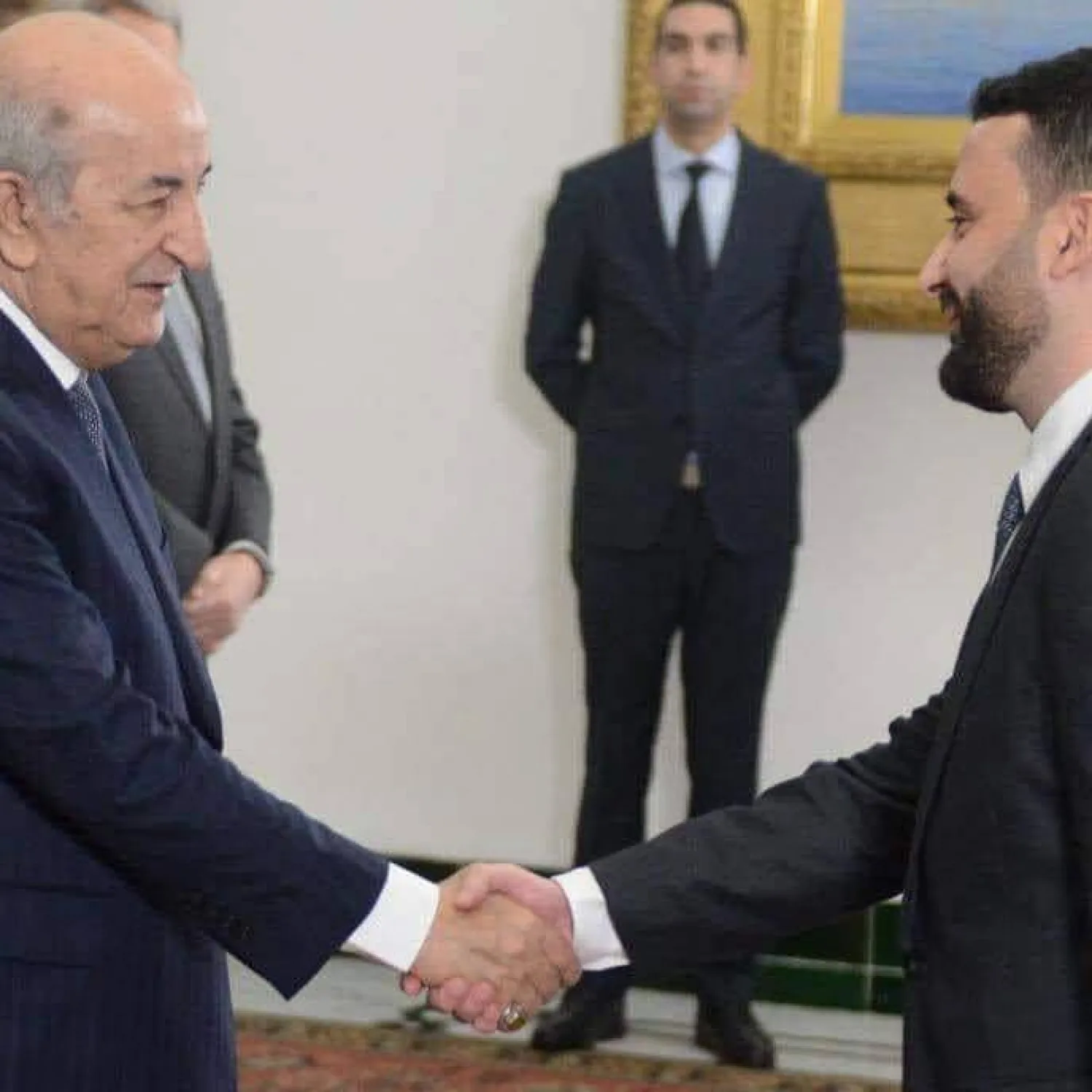 الوزير ضيافات المسجون بتهمة الفساد يصافح الرئيس تبون... وفي الخلف مدير البروتوكول الرئاسي المسجون (أرشيفية - حسابات ناشطين بمجال التبليغ عن الفساد)