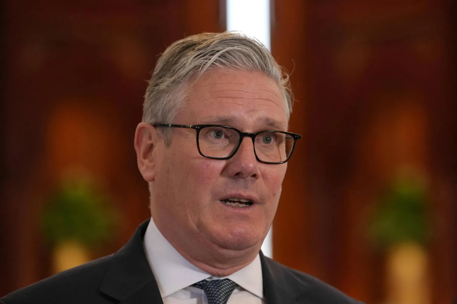 رئيس الوزراء البريطاني كير ستارمر يتحدث إلى وسائل الإعلام في مطار الدوحة الجمعة (أ.ف.ب)