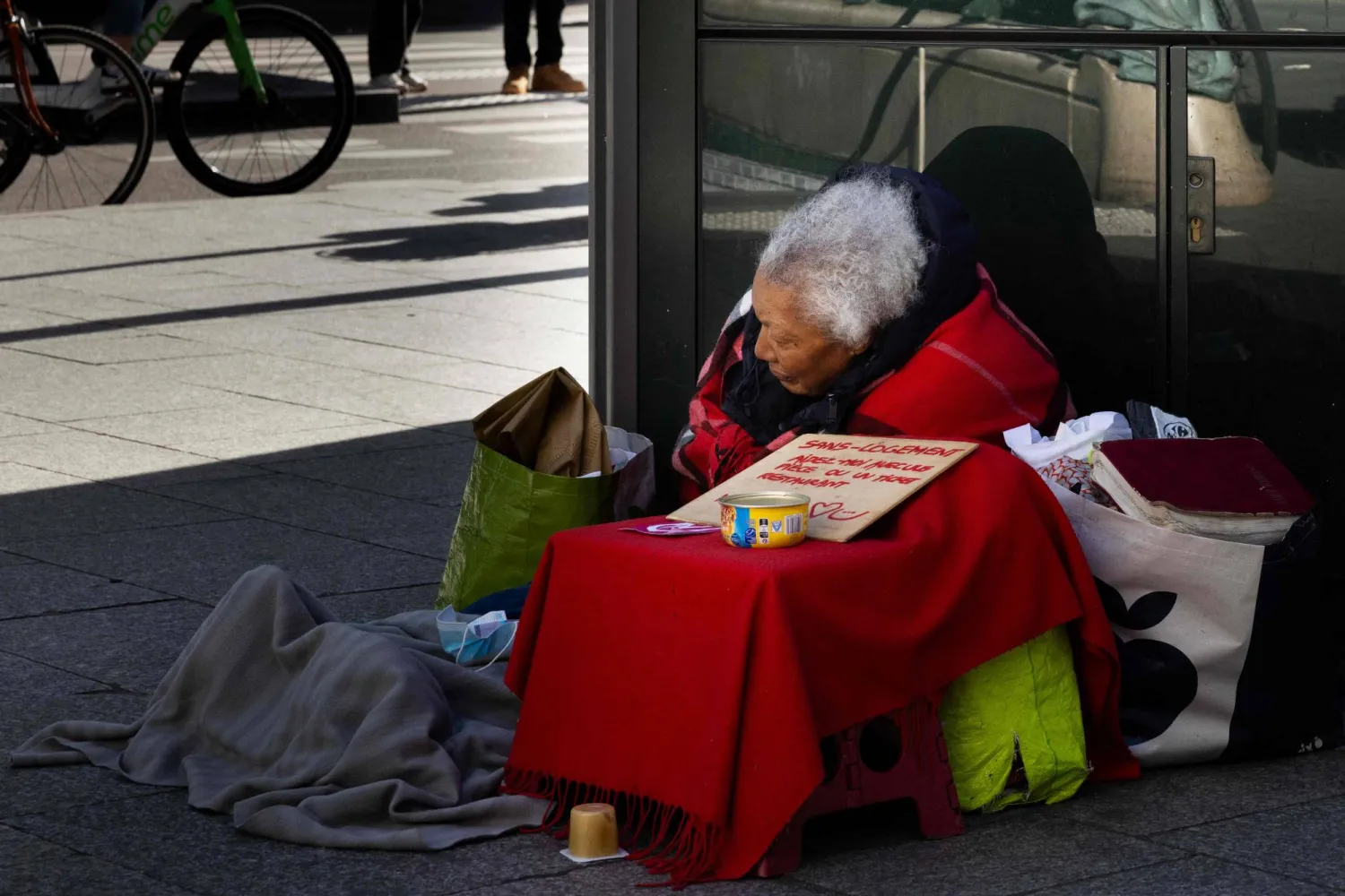 امرأة بلا مأوى تجلس في أحد شوارع باريس (أ.ف.ب)