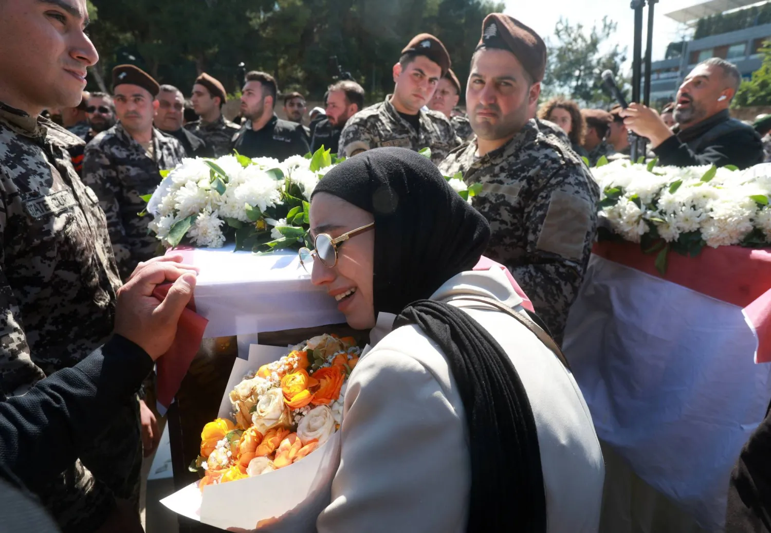 لبنانية وعناصر في أمن الدولة يبكون 13 عسكرياً قُتلوا في استهداف إسرائيلي لمقر «أمن الدولة» في النبطية وشُيّعوا في مراسم عسكرية السبت (رويترز)