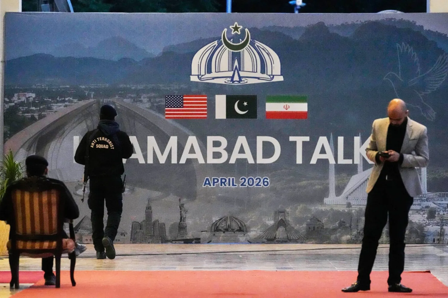 رجل أمن أمام لوحة لمحادثات إسلام آباد خارج مركز إعلامي أُقيم لتغطية المفاوضات بين الولايات المتحدة وإيران (ا.ب)