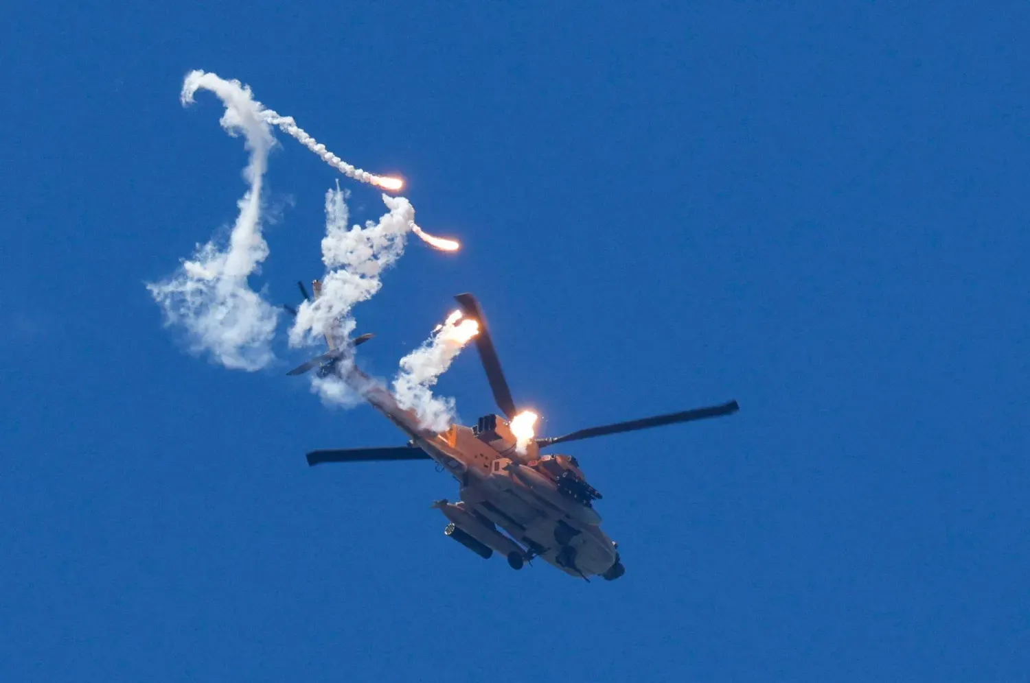  İsrail’e ait bir Apache helikopteri Lübnan üzerinde uçarken işaret fişekleri ateşliyor. (Reuters)