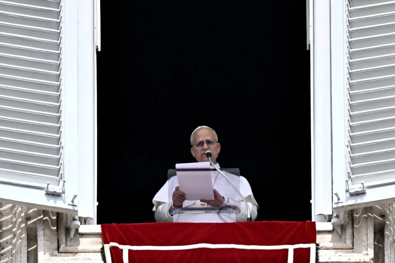 Pope Leo XIV addresses the crowd from the window of the apostolic palace overlooking St. Peter's square during the Regina Caeli prayer in The Vatican on April 12, 2026. (Photo by Filippo MONTEFORTE / AFP)