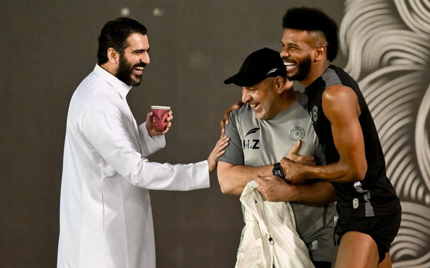 البليهي يمازح مدربه بن زكري ويظهر عبد العزيز المالك رئيس الشباب (موقع النادي)