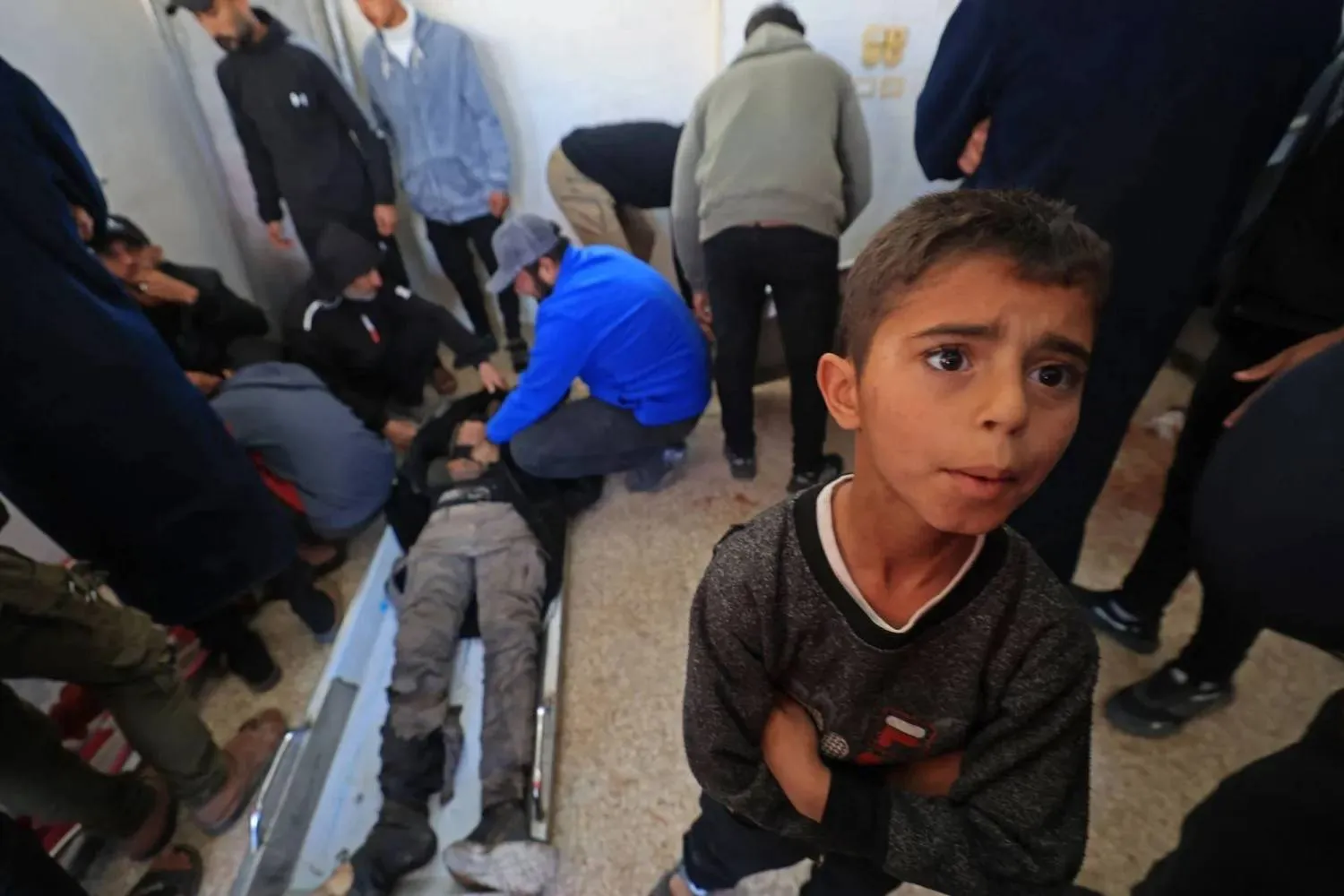 In the Al-Aqsa Martyrs' Hospital in Deir al-Balah in the center of the Gaza Strip, mourners gather around the bodies of two Palestinians killed in an Israeli strike (AFP) 