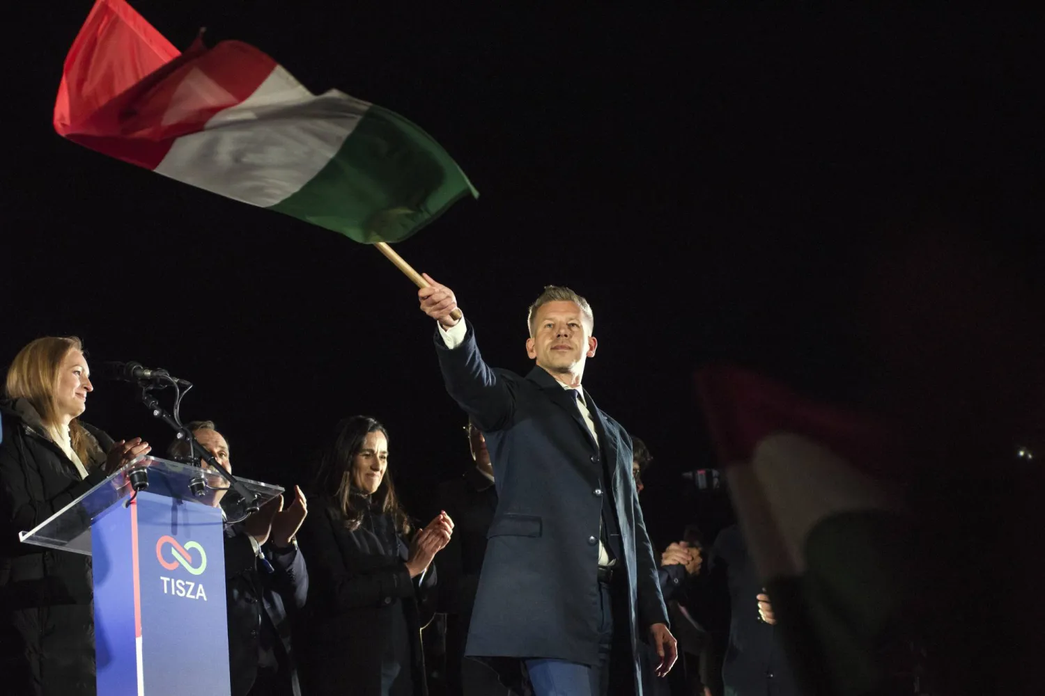 مرشح المعارضة بيتر ماغيار يلوّح بالعَلم المجري خلال الاحتفال بالفوز الانتخابي في بودابست فجر الاثنين (د.ب.أ)