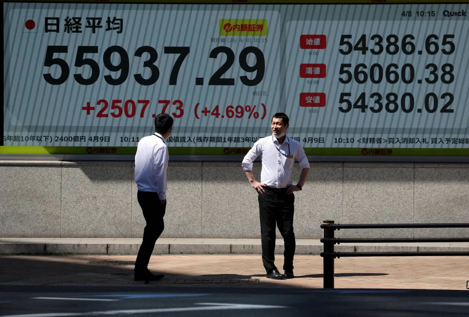 مشاة يمرُّون أمام شاشة تعرض حركة الأسهم في العاصمة اليابانية طوكيو (رويترز)