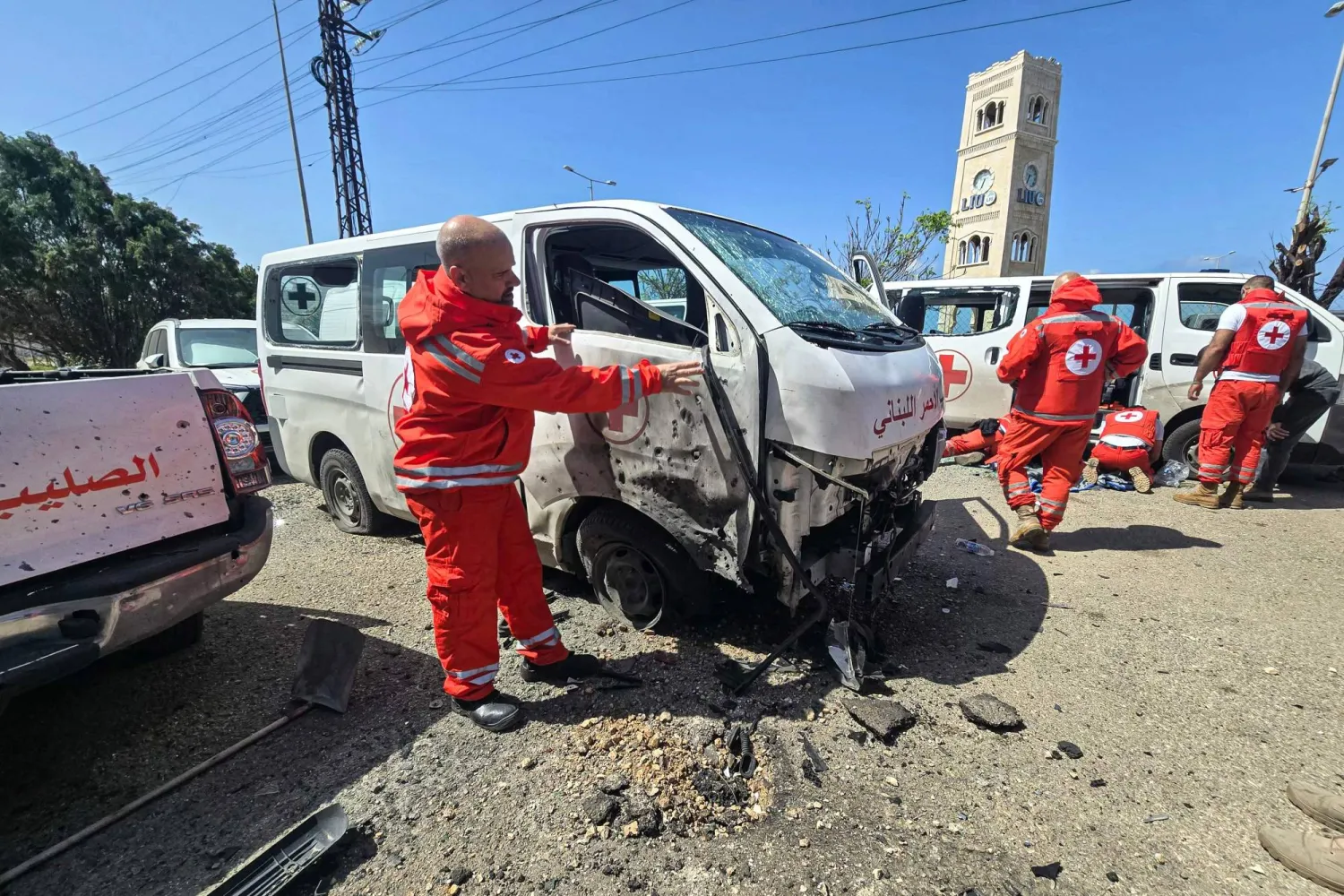 Lebanese Red Cross volunteers inspect the damage to their rescue vehicles at the site of an Israeli drone strike that targeted their headquarters in the southern city of Tyre on April 13, 2026. (Photo by Kawnat HAJU / AFP)