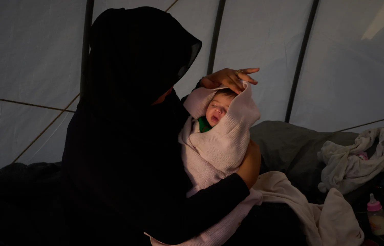 Haifa Kenjo, who fled Israeli airstrikes on the southern suburbs of Beirut, holds her 15-day-old daughter Shiman inside the tent she uses as a shelter and where she gave birth to her in Beirut, Sunday, April 12, 2026. (AP Photo/Emilio Morenatti)