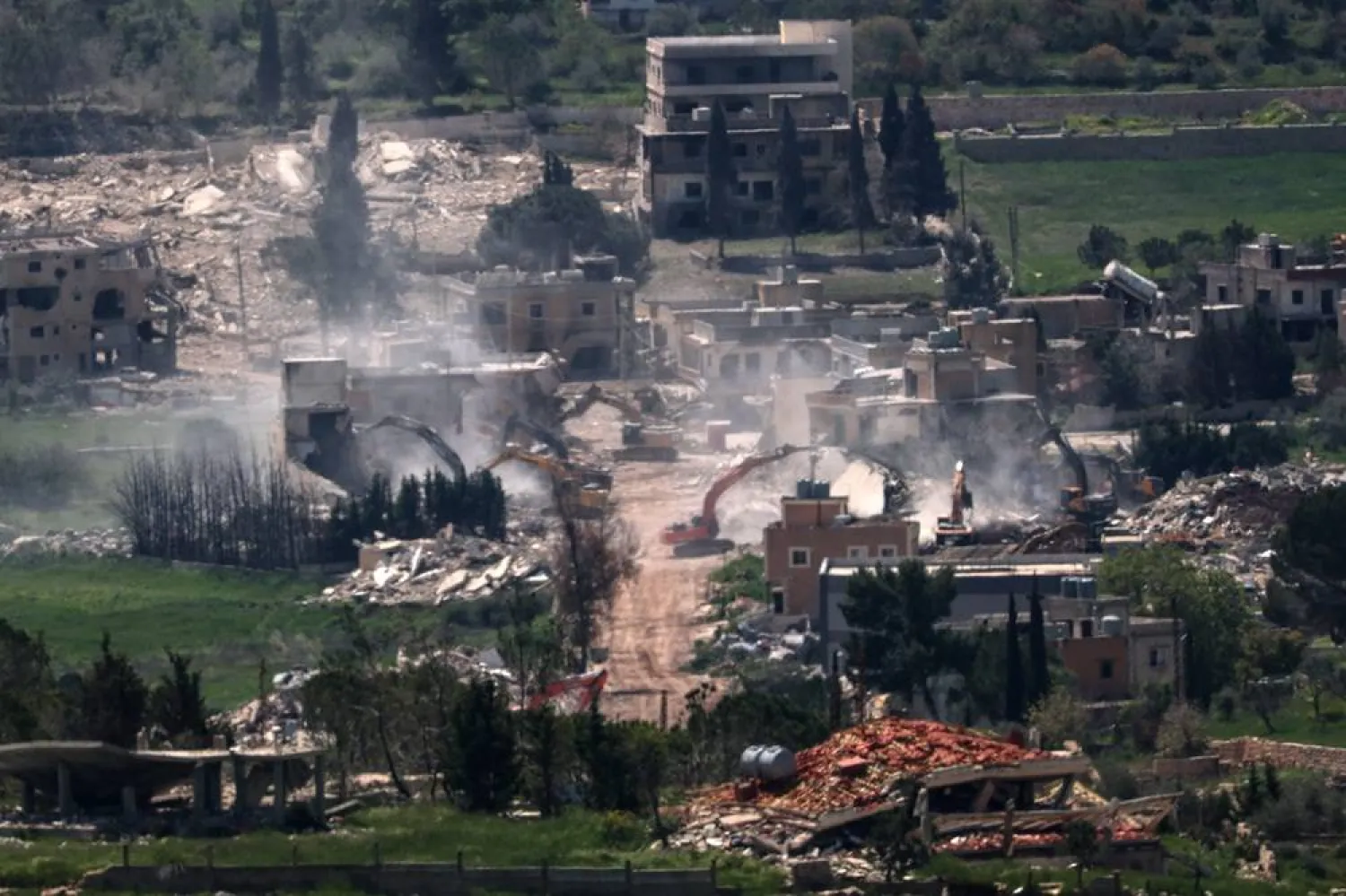 Israeli army excavators demolish buildings in the southern Lebanese village of Mais al-Jabal, as seen from the Israeli side of the border, 13 April 2026. (EPA)
