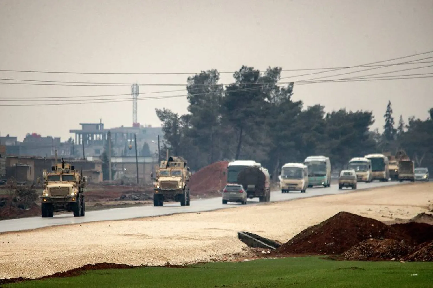 US military vehicles move along a road in a convoy transporting ISIS group detainees being transferred to Iraq from Syria, on the outskirts of Qahtaniyah in Syria's northeastern Hasakeh province on February 7, 2026. (AFP) 