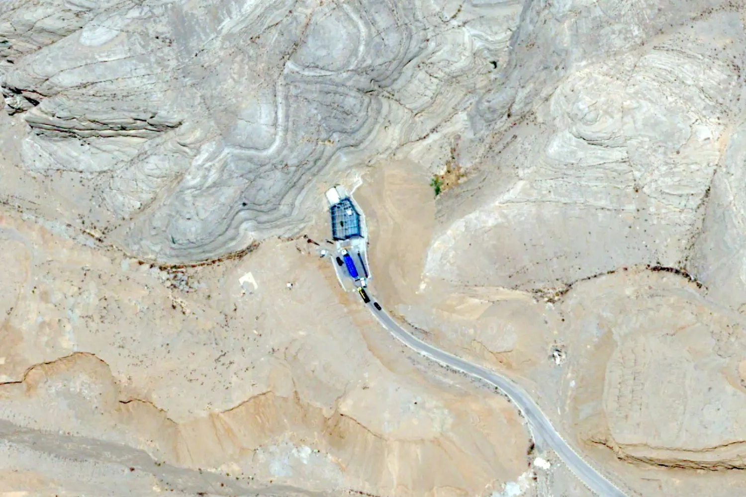 تُظهِر هذه الصورة الملتقَطة بواسطة القمر الاصطناعي «بلياديس نيو» التابع لشركة «إيرباص للدفاع والفضاء» شاحنة محمَّلة بـ18 حاوية زرقاء تنقل يورانيوم عالي التخصيب تدخل إلى نفق داخل مجمع «مركز التكنولوجيا النووية» في أصفهان 9 يونيو 2025 (أ.ب)