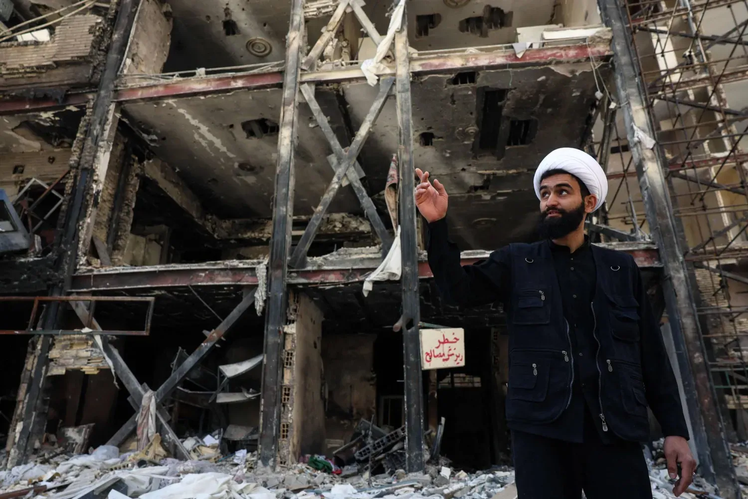 Dün Tahran’da İran ile ABD arasında iki haftalık ateşkesin yürürlüğe girmesinden birkaç gün önce ABD-İsrail hava saldırılarının hedefi olan bir apartmanın önünde gazetecilere açıklamalarda buluanan İranlı bir din adamı (AFP)