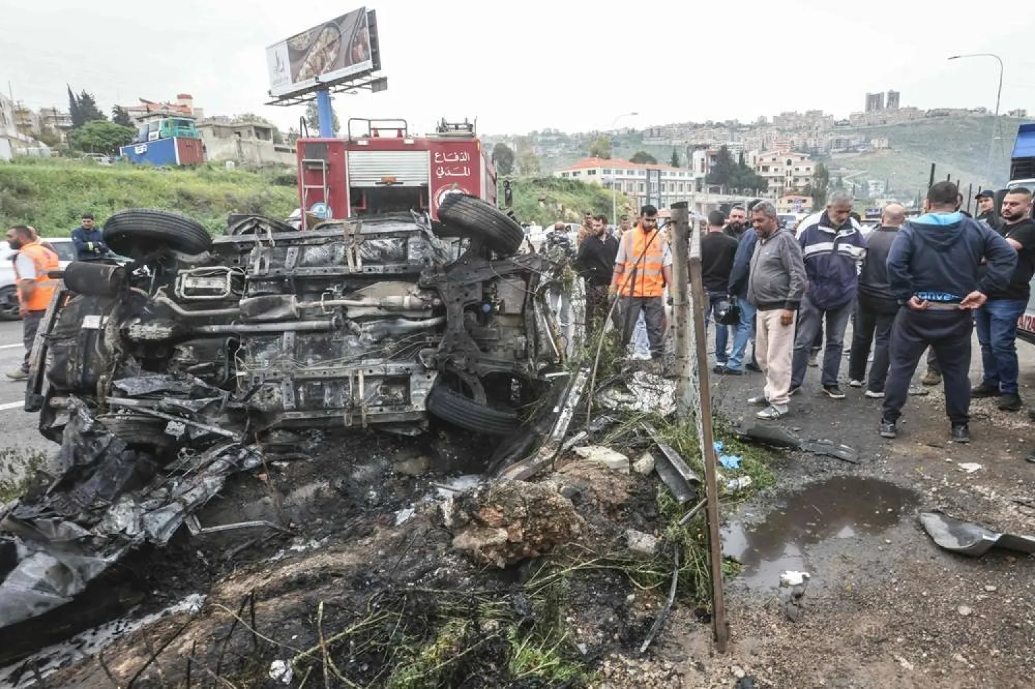 First responders and security forces work at the site of an Israeli airstrike that targeted a vehicle the Lebanese town of Jiyyeh, south of Beirut, on April 15, 2026. (AFP)