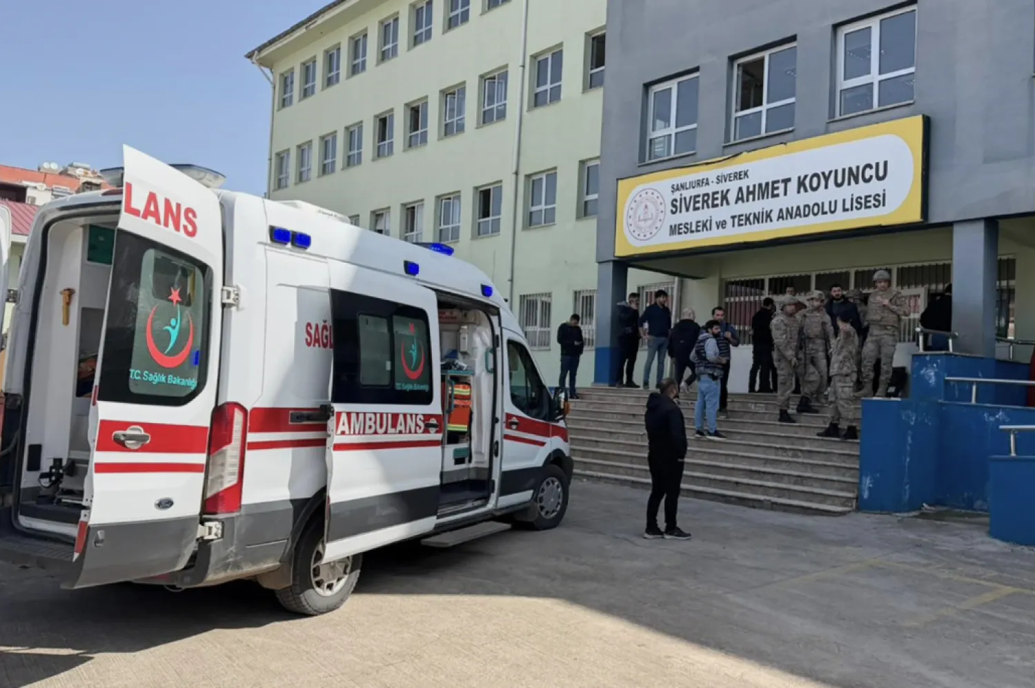 Turkish security forces and emergency staff stand at the courtyard of a high school where an assailant opened fire, in Siverek, south east Türkiye, Tuesday, April 14, 2026, (Mevlut Bayraktar/IHA via AP)


