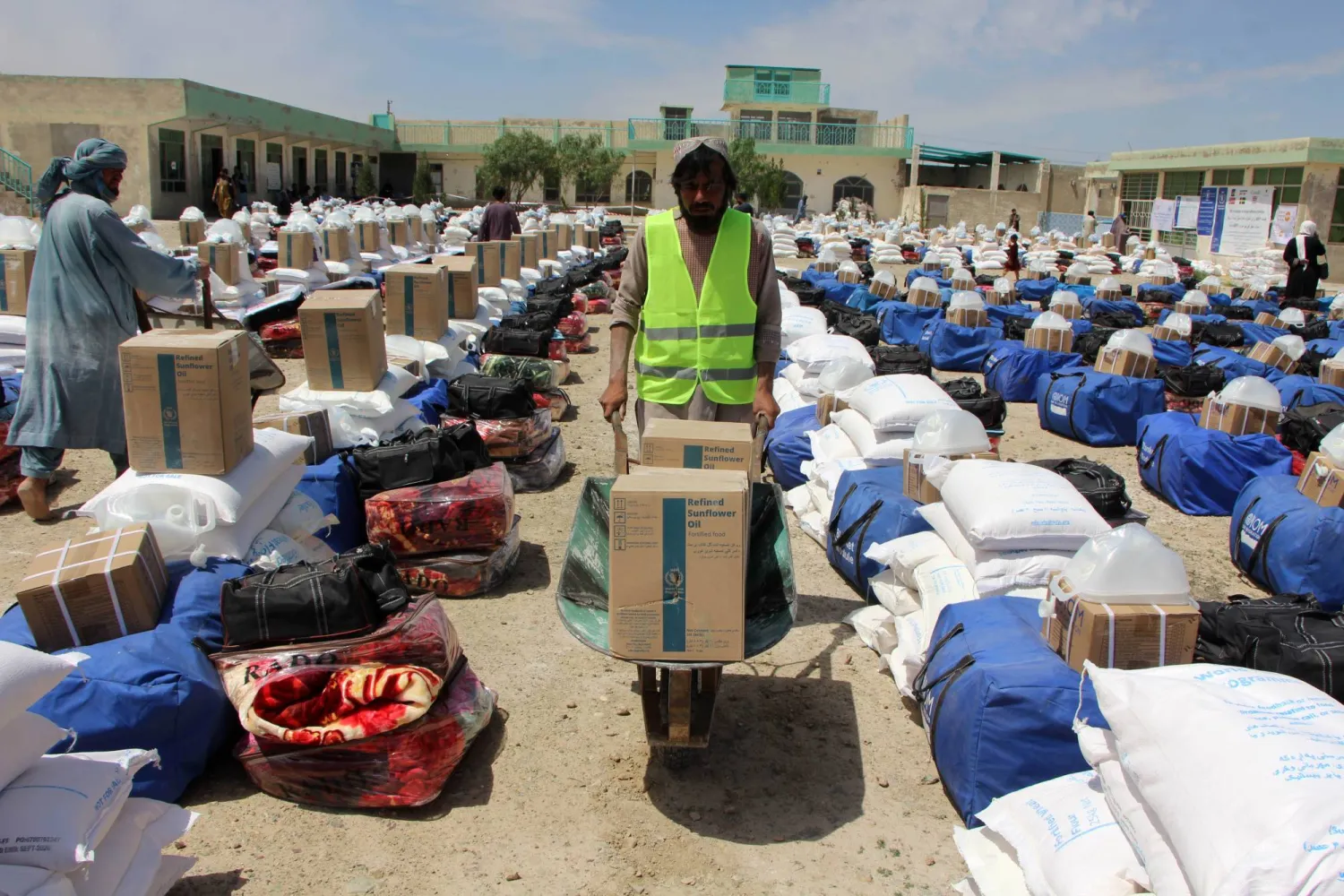 أناس متأثرون بالفيضانات يتلقون مساعدات في قندهار بأفغانستان (إ.ب.أ)