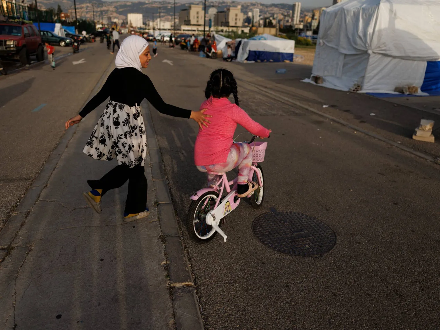 طفلتان نازحتان تلعبان بأحد مراكز النزوح في بيروت (رويترز)