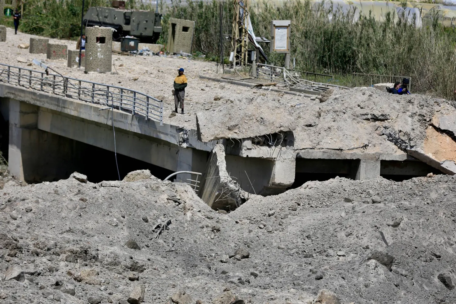 A man stands on a damaged part of the Qasmiyeh Bridge that was targeted by an Israeli airstrike near Tyre, southern Lebanon, 16 April 2026. EPA/STRINGER