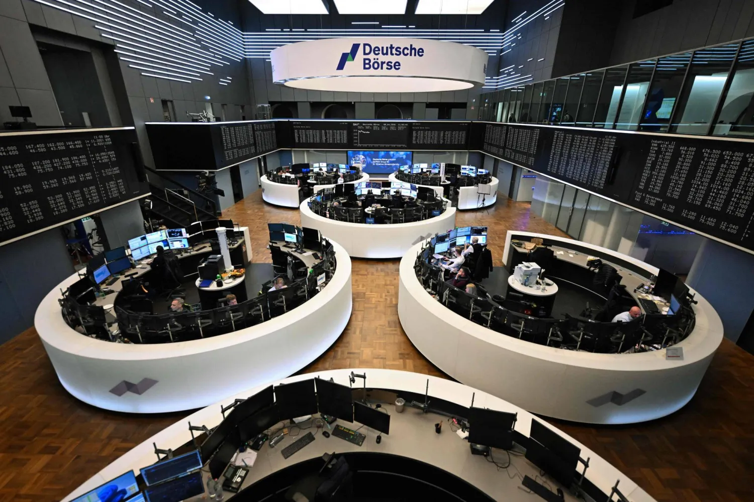 متداولون يعملون أمام شاشة تعرض مؤشر الأسهم الألماني «داكس» في بورصة فرانكفورت (أ.ف.ب)