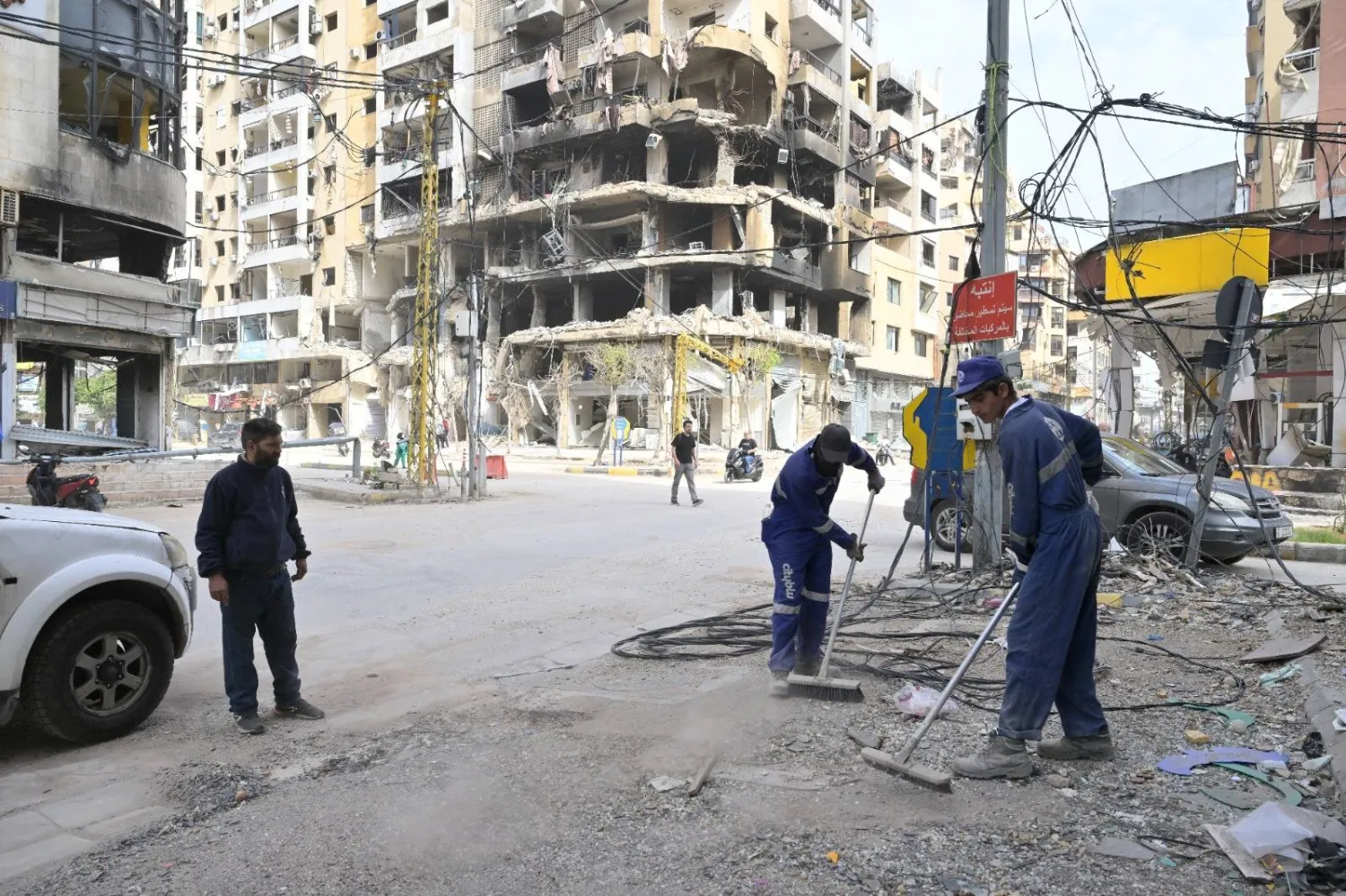 عمال ينظفون شوارع الضاحية الجنوبية لبيروت من الركام تمهيداً لعودة السكان (الشرق الأوسط)