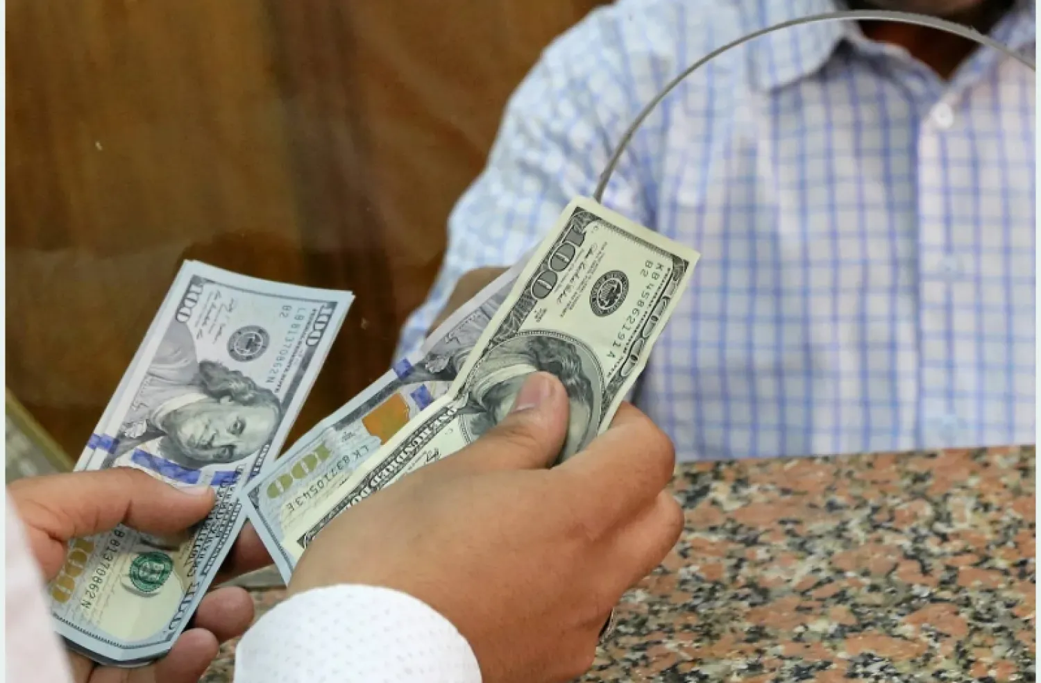 مواطن يستبدل دولارات من داخل صرافة في القاهرة (رويترز)