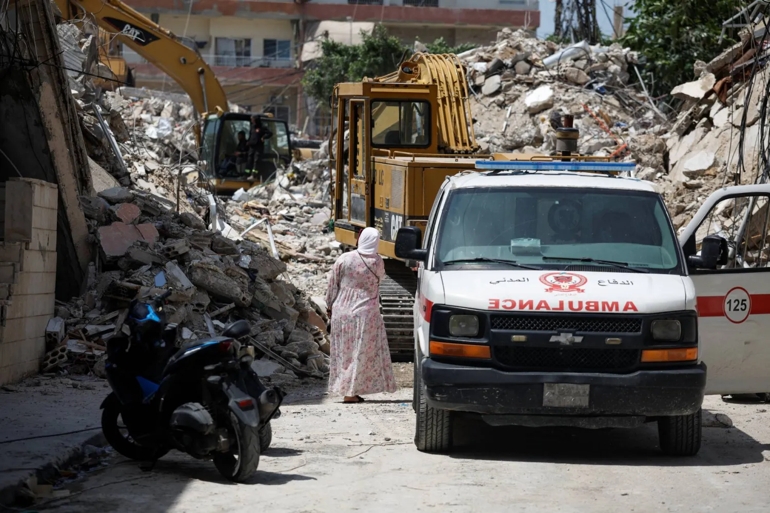 A woman walks next to an ambulance at the site of an Israeli strike carried out before a 10-day ceasefire between Lebanon and Israel went into effect, in Tyre, Lebanon, April 17, 2026. (Reuters)