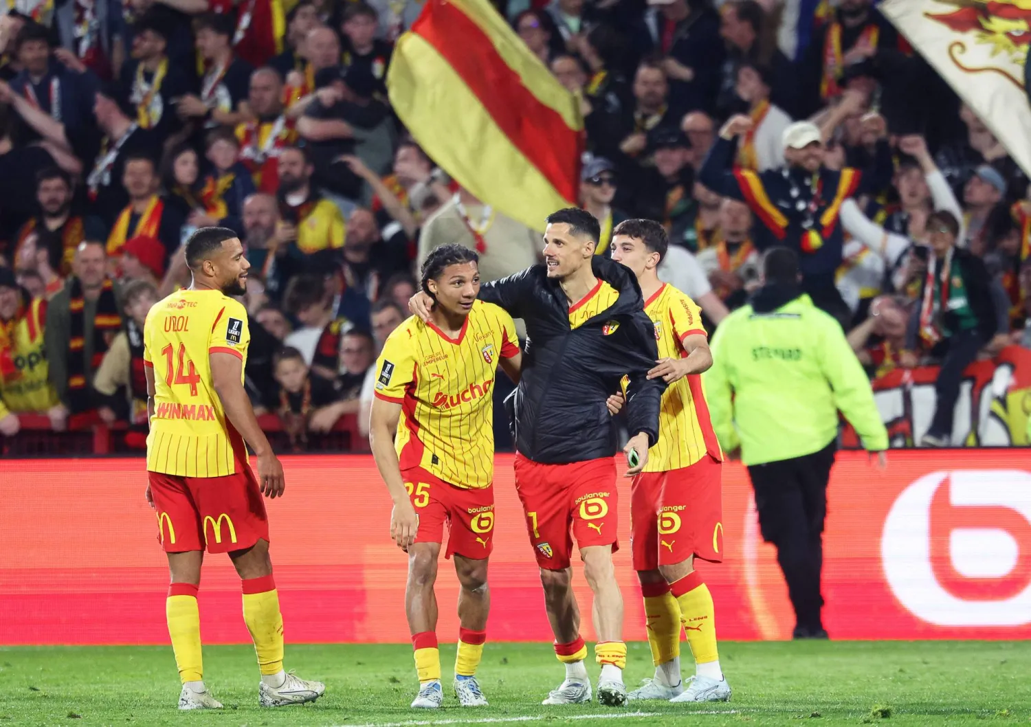 مدافع «لنس» إسماعيلو غانيو يحتفل بتسجيل هدف مع زميله المُهاجم فلوريان سوتوكا أمام «تولوز» (أ.ف.ب)